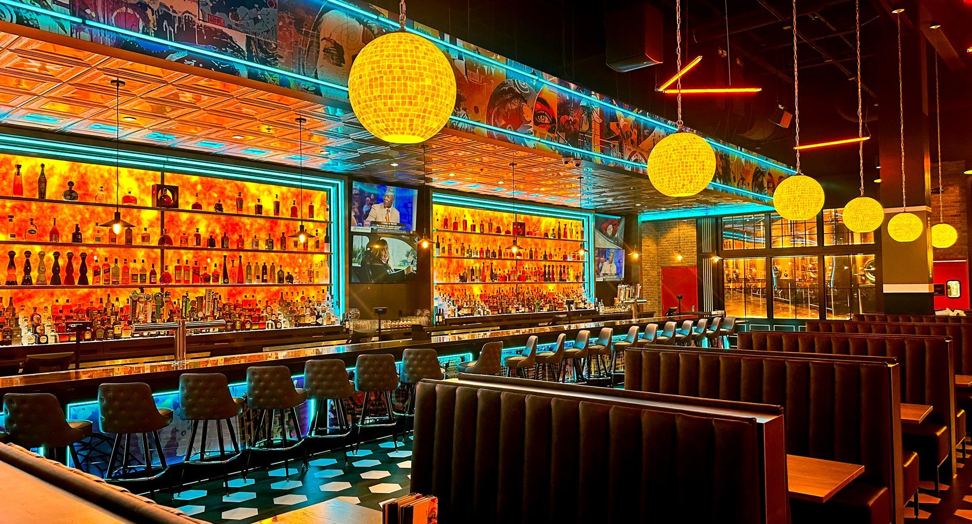 Beautifully lit bar with booths in the foreground.