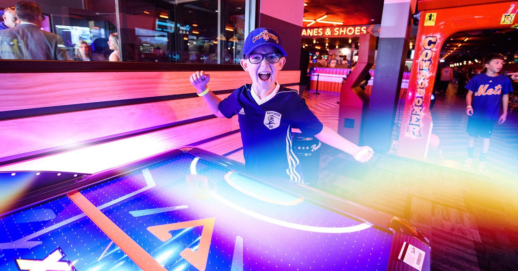 Kid celebrating and smiling in arcade