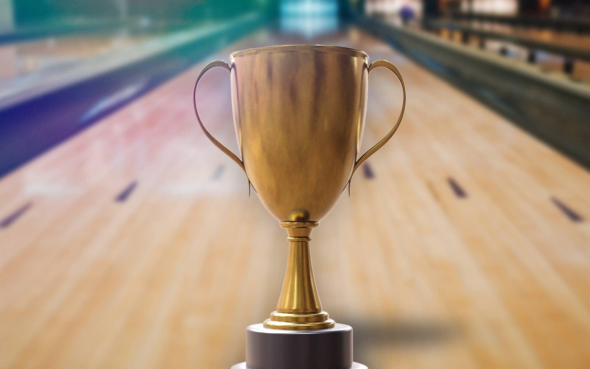 bowling trophy sitting on a bowling lane. 