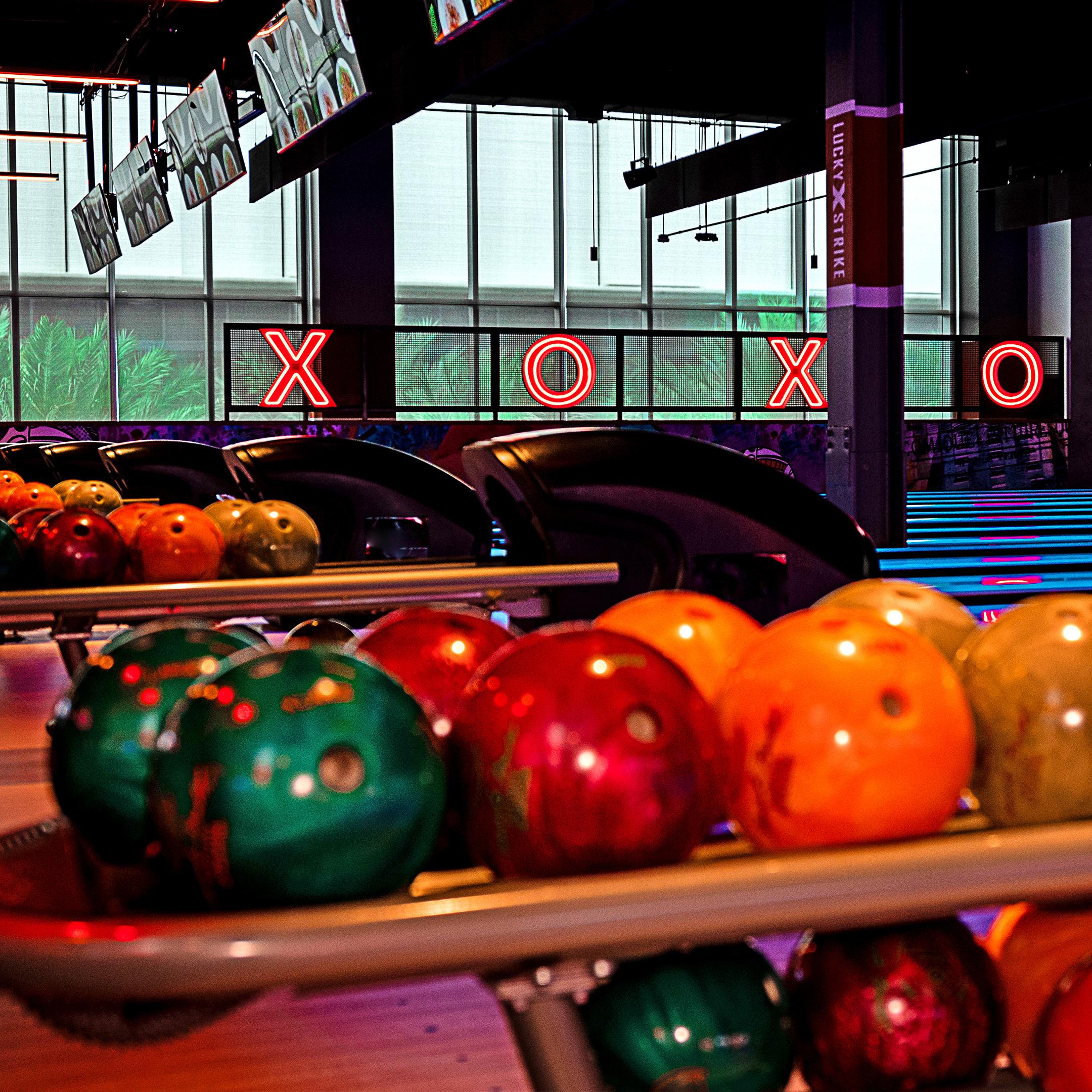 Colorful bowling balls with bowling lanes in background