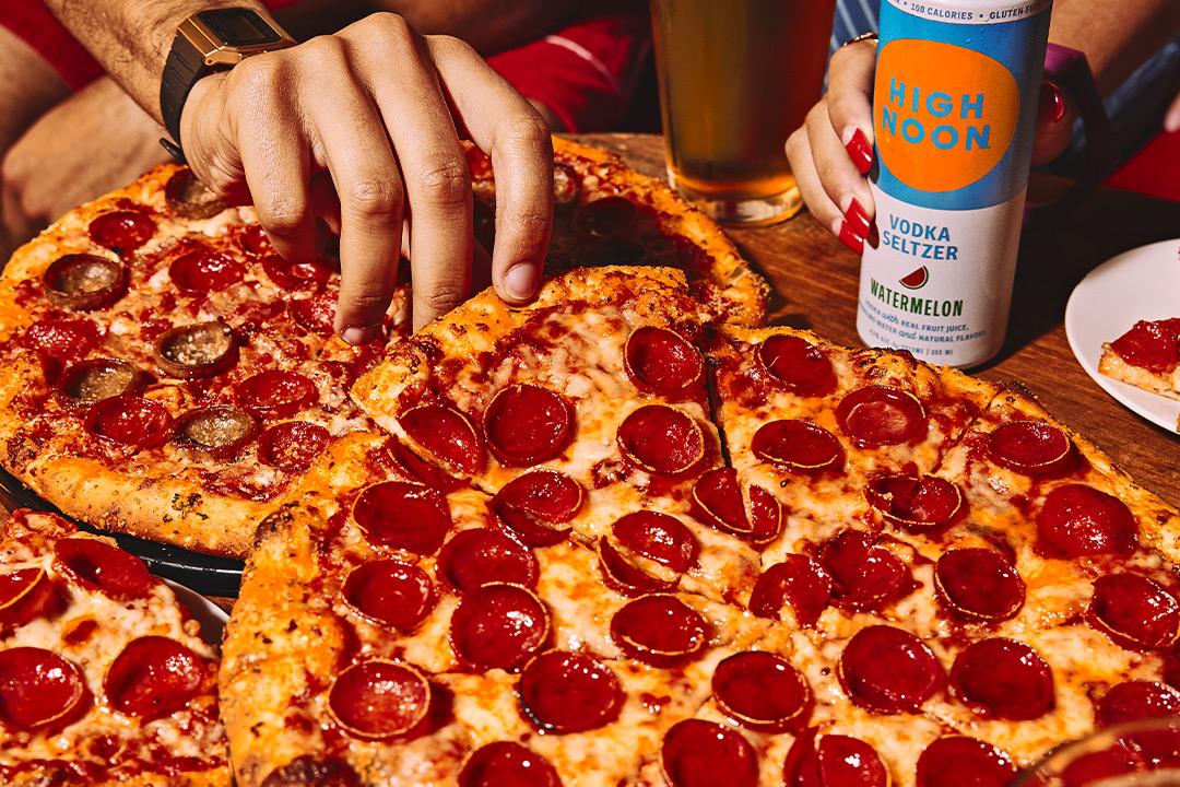 Pizza sitting on a tray with a high noon in the background. 