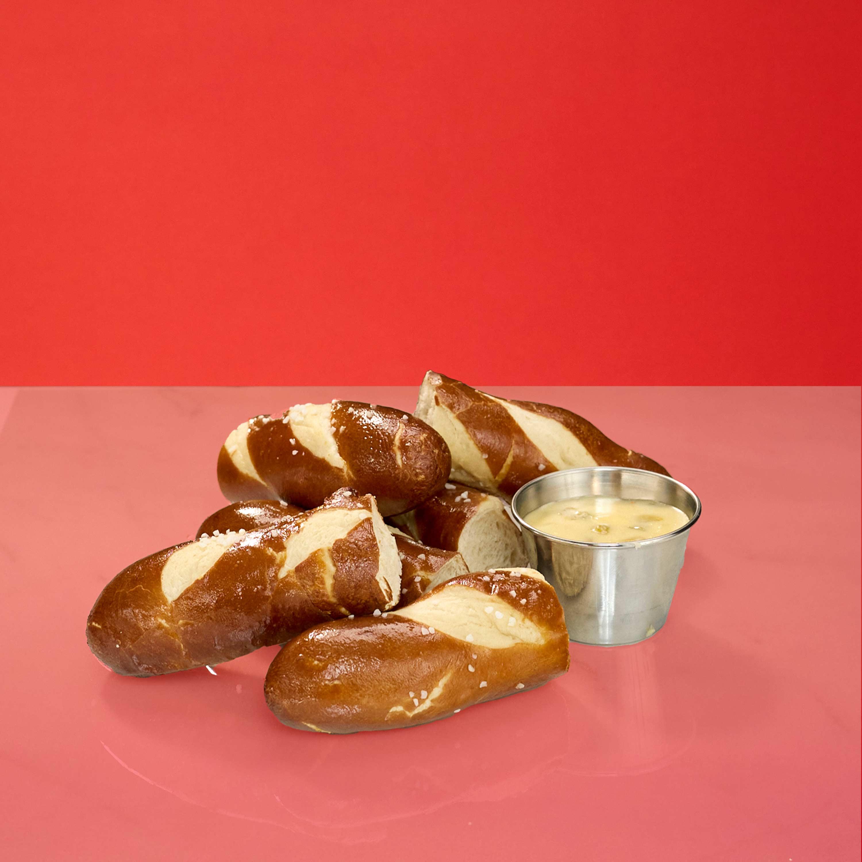 Freshly baked and lightly salted pretzel bites with queso dipping sauce