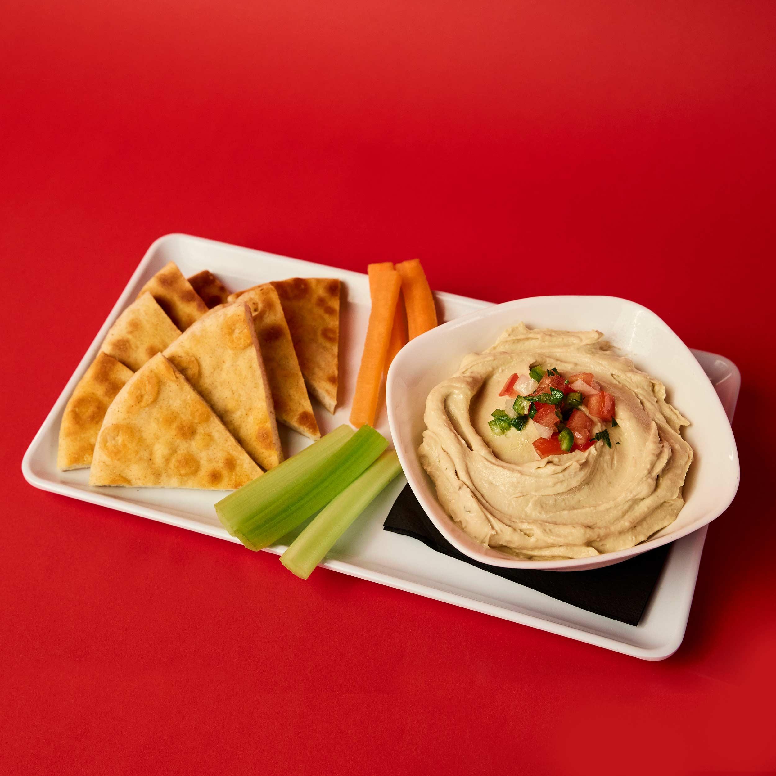 Hummus served with carrots, celery, and grilled pita.