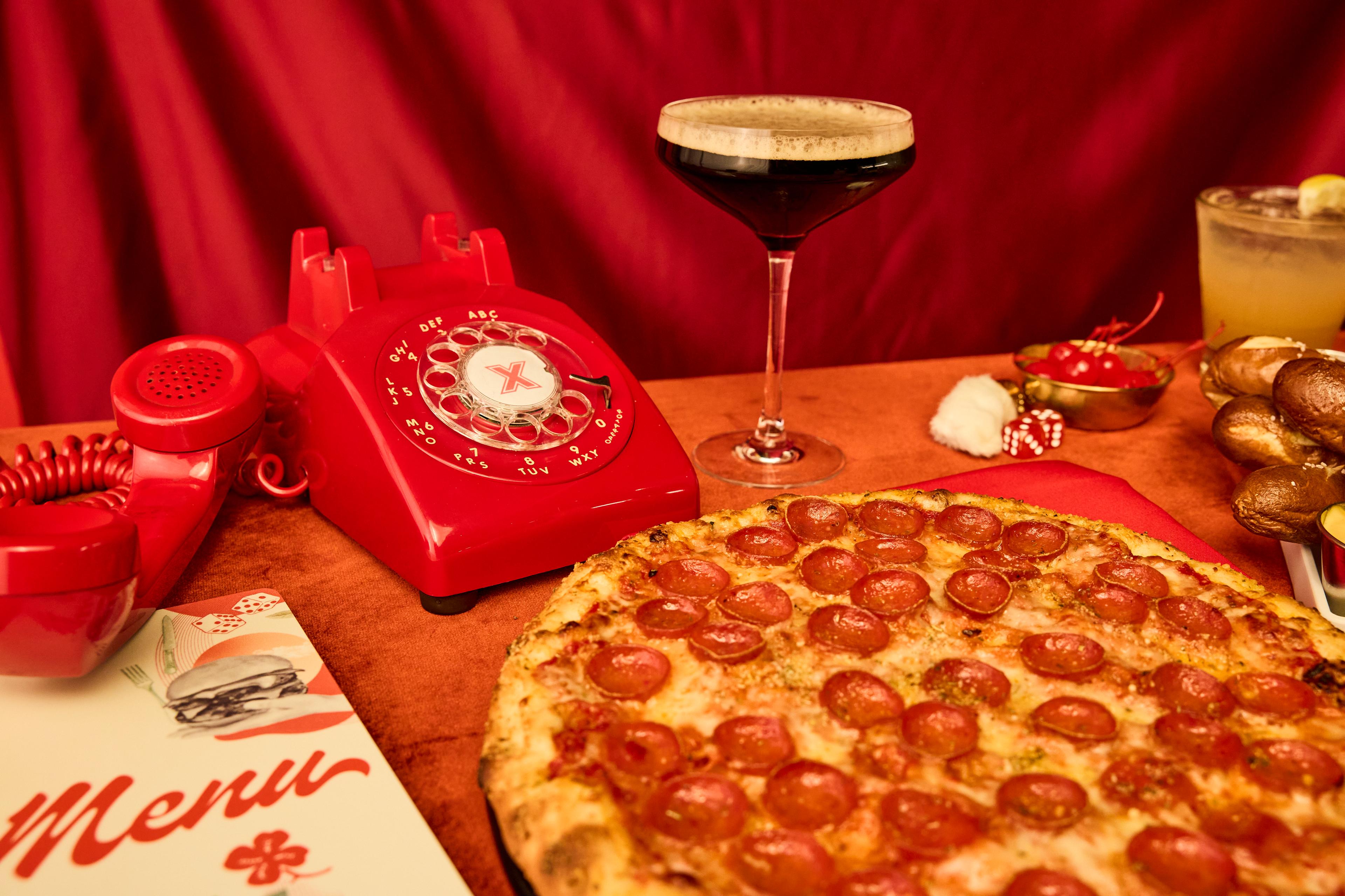 Pizza and a phone with an espresso martini. 