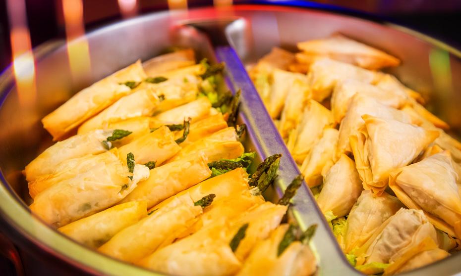 Filo wrapped asparagus and spanakopita set up in a buffet display. 