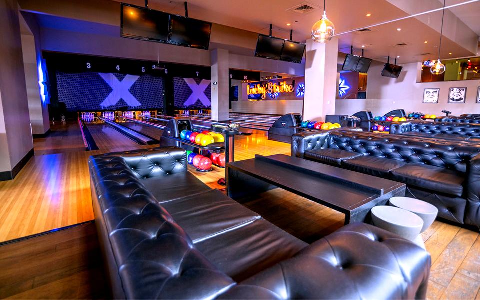 Large and comfortable couches with bowling lanes in the background