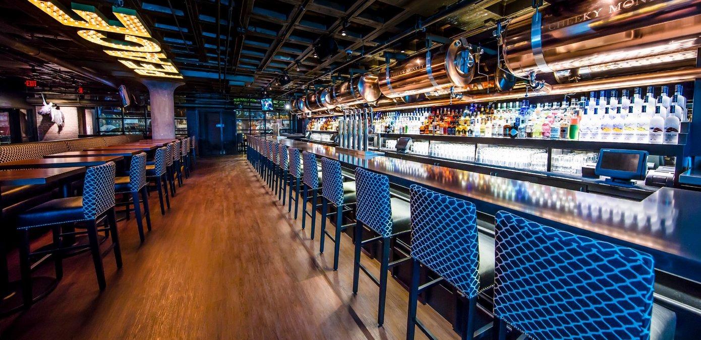 Bar stools lined up neatly in front of a larger bar