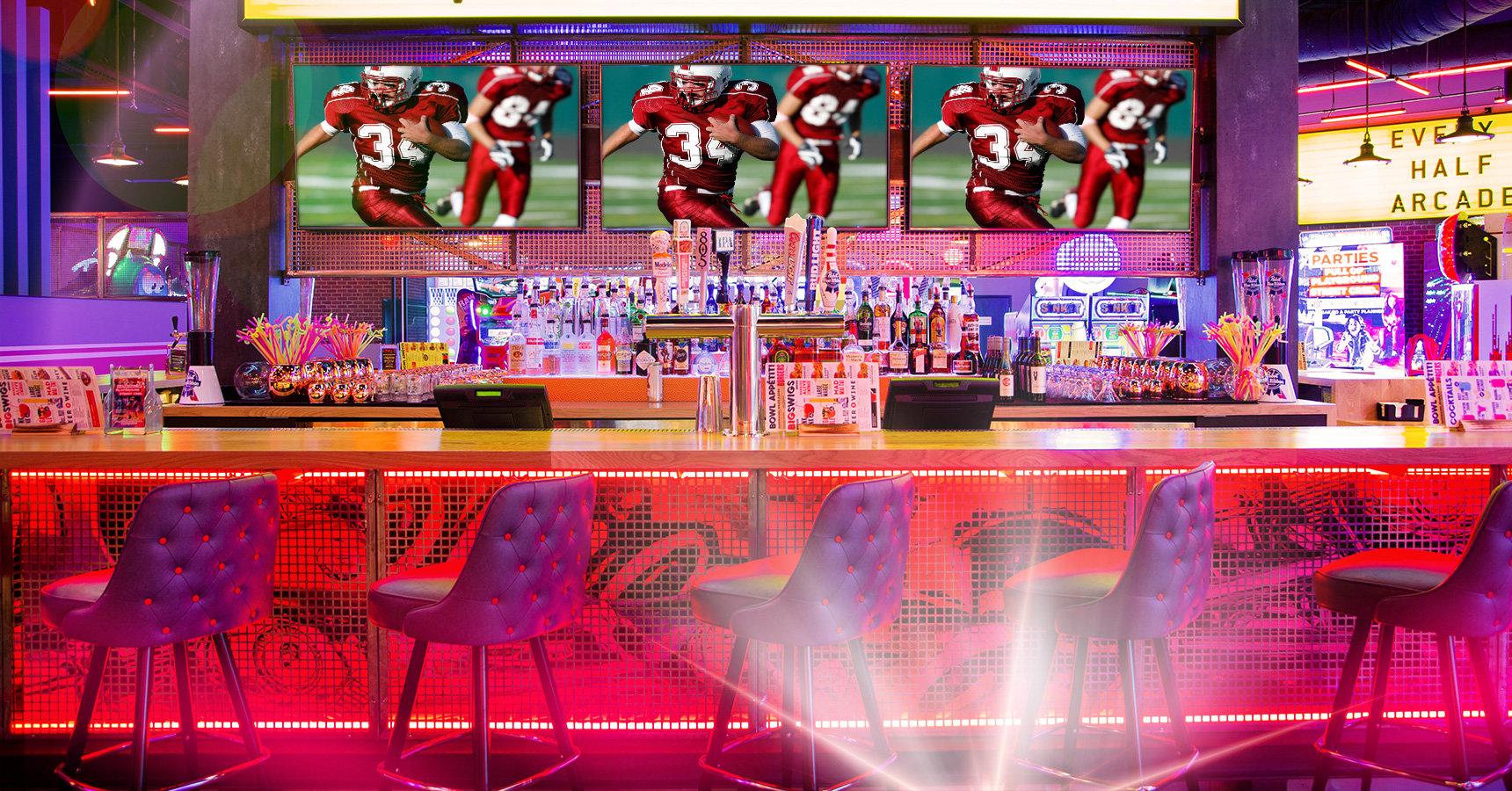 Beautiful bar with football on TV screens behind the bar