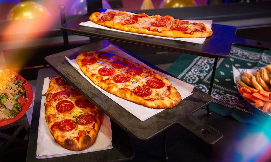 Pepperoni flatbreads are displayed and stacked on a stand. 