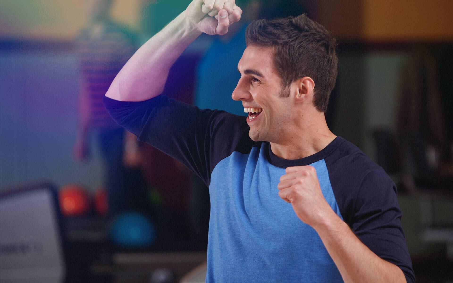 A man cheering on a bowling lane.