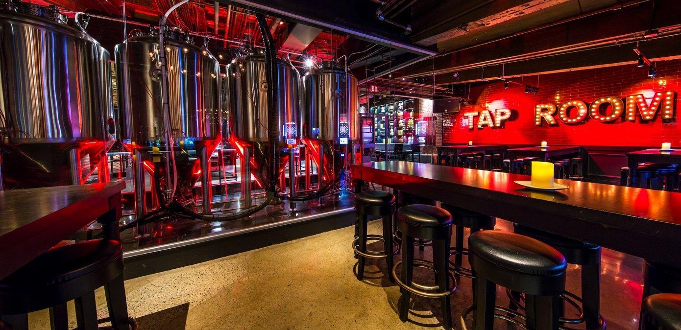 Barstools, tables, and large brewery casks in a tap room