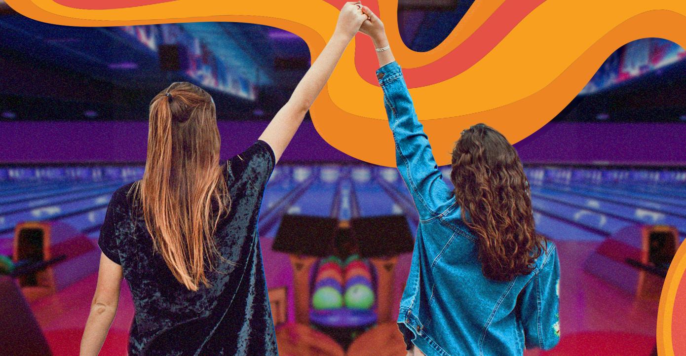 Two girls holding hands at the bowling lanes with orange waves in the photo. 