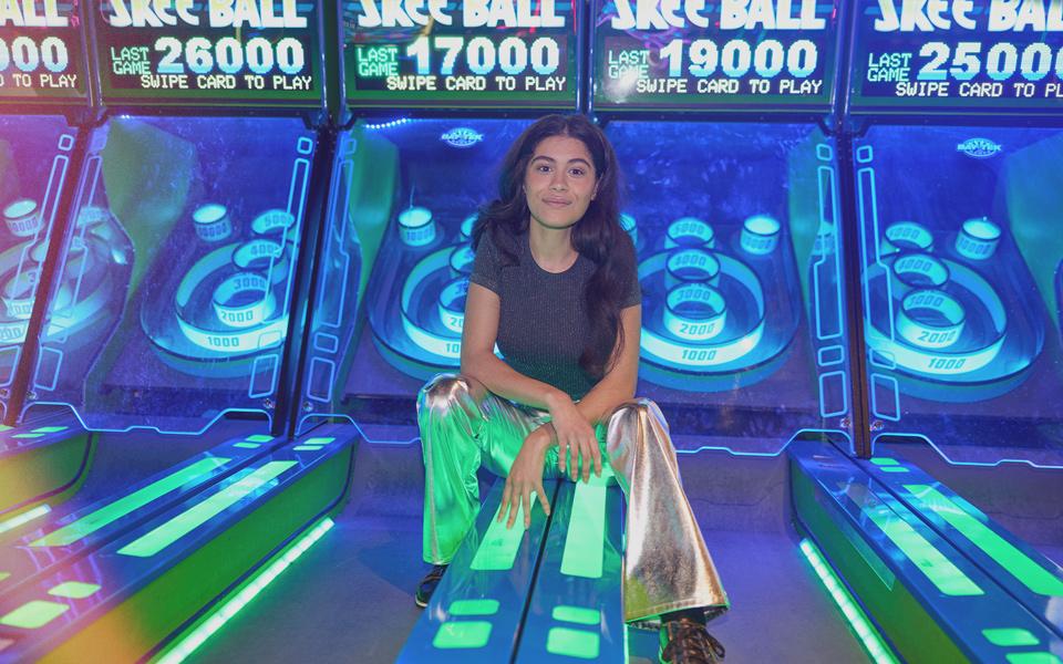 Person sitting on skee ball game